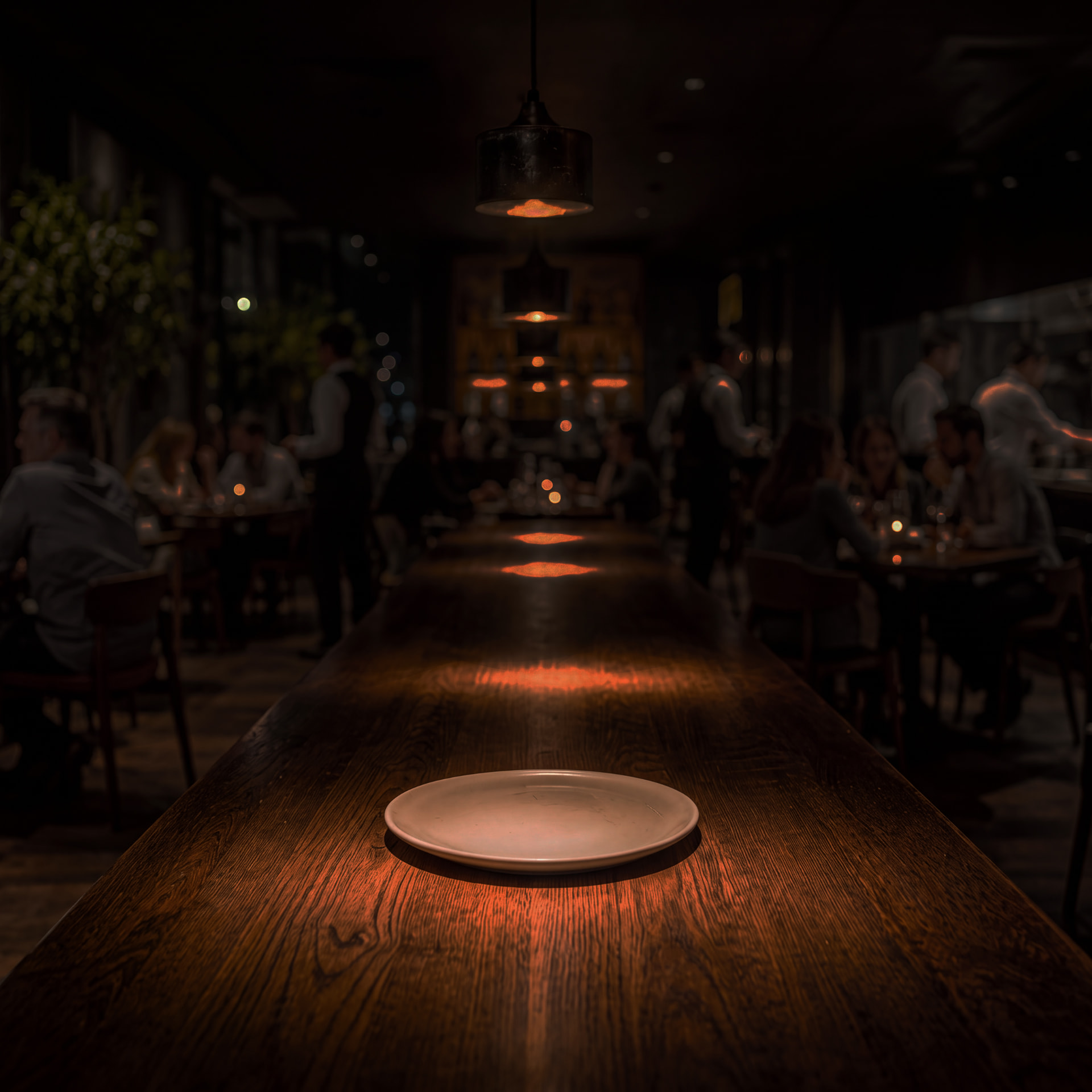 A candlelit restaurant table with an empty plate
